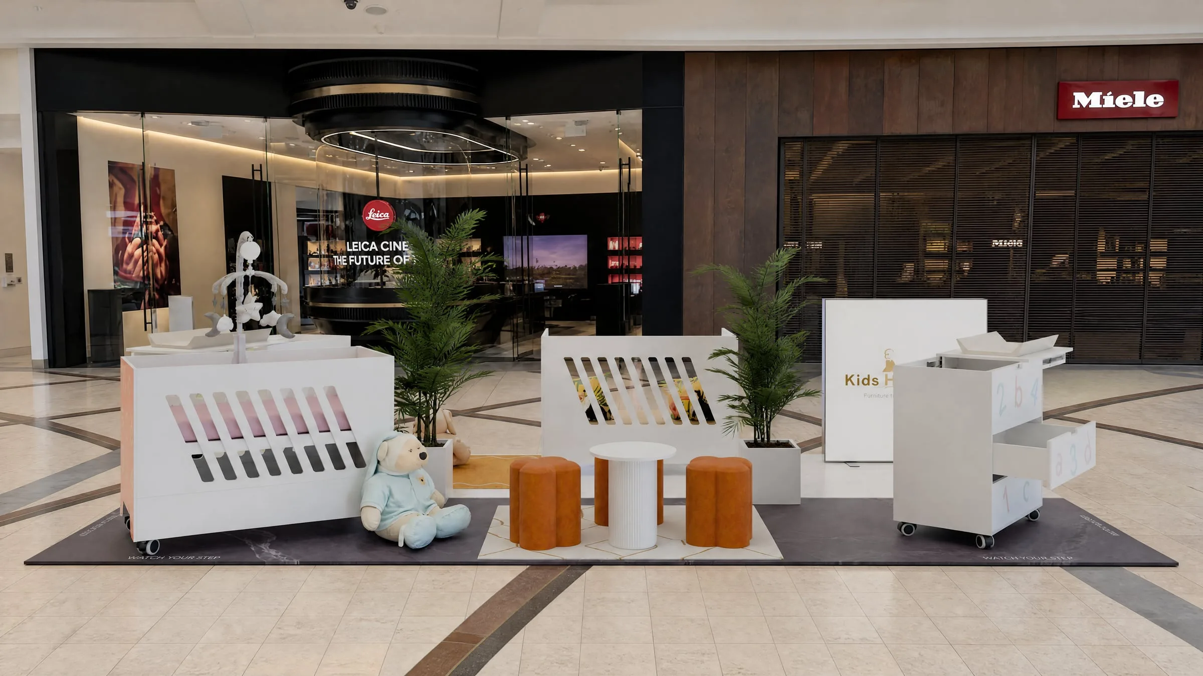The kiosk in the mall concourse with product rails and a play area