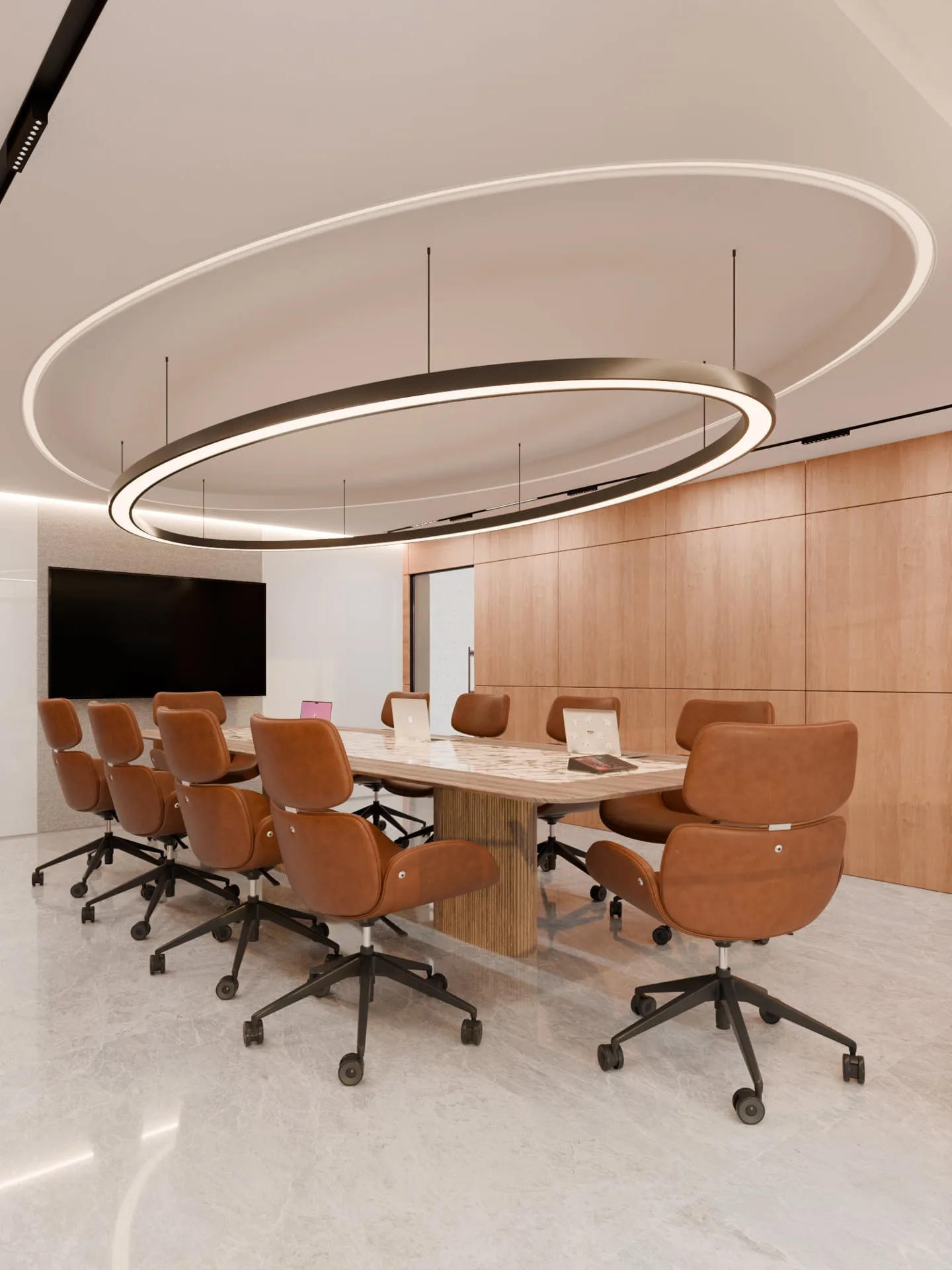 Boardroom with a ring pendant over a marble table and tan leather chairs