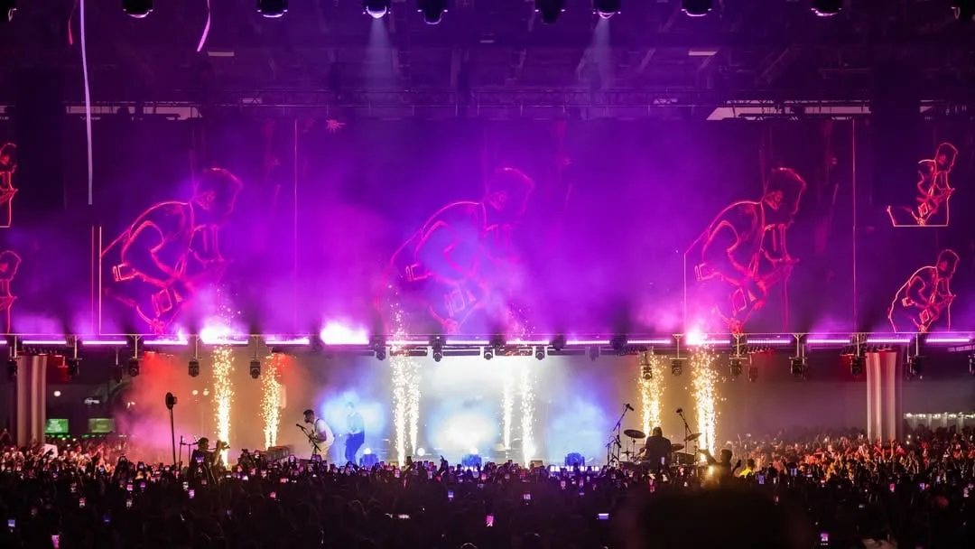 Purple wash over the stage with white pyro columns along the front edge