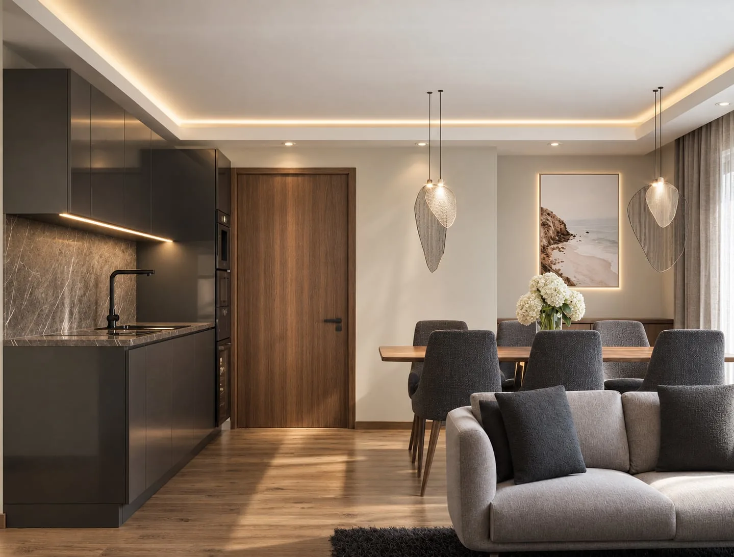 An open-plan living room with the kitchen along the left wall, dining table and sofa sharing the space under pendant lights