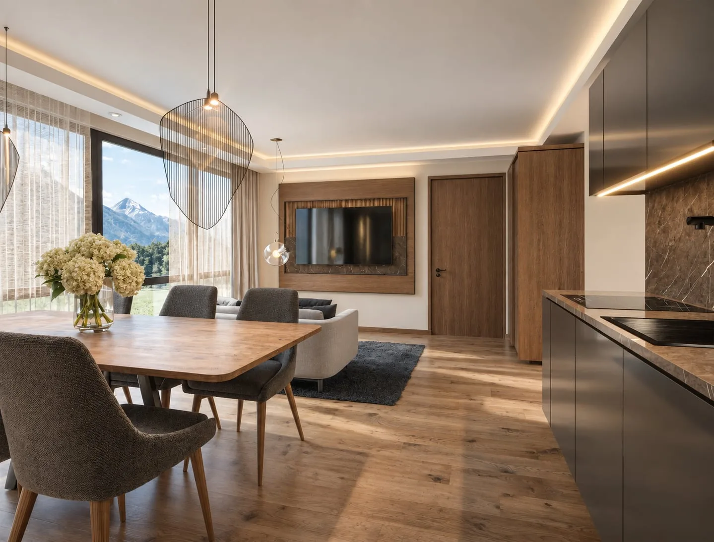 A dining table dressed with flowers, the kitchen run to the right and the peaks visible past the curtain